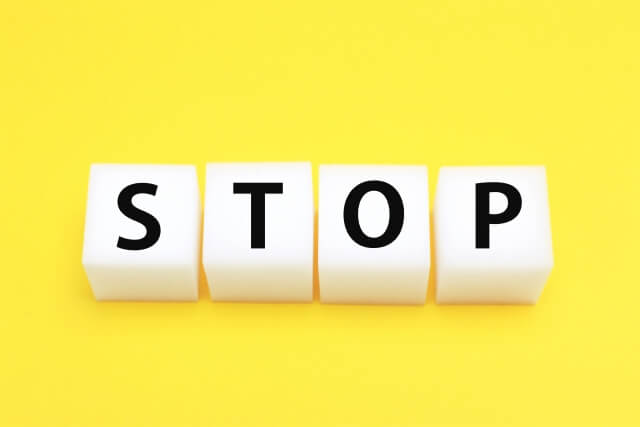 黄色い背景に「STOP」と書かれた4つのサイコロ