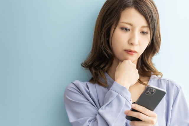 スマホを見て考えている女性